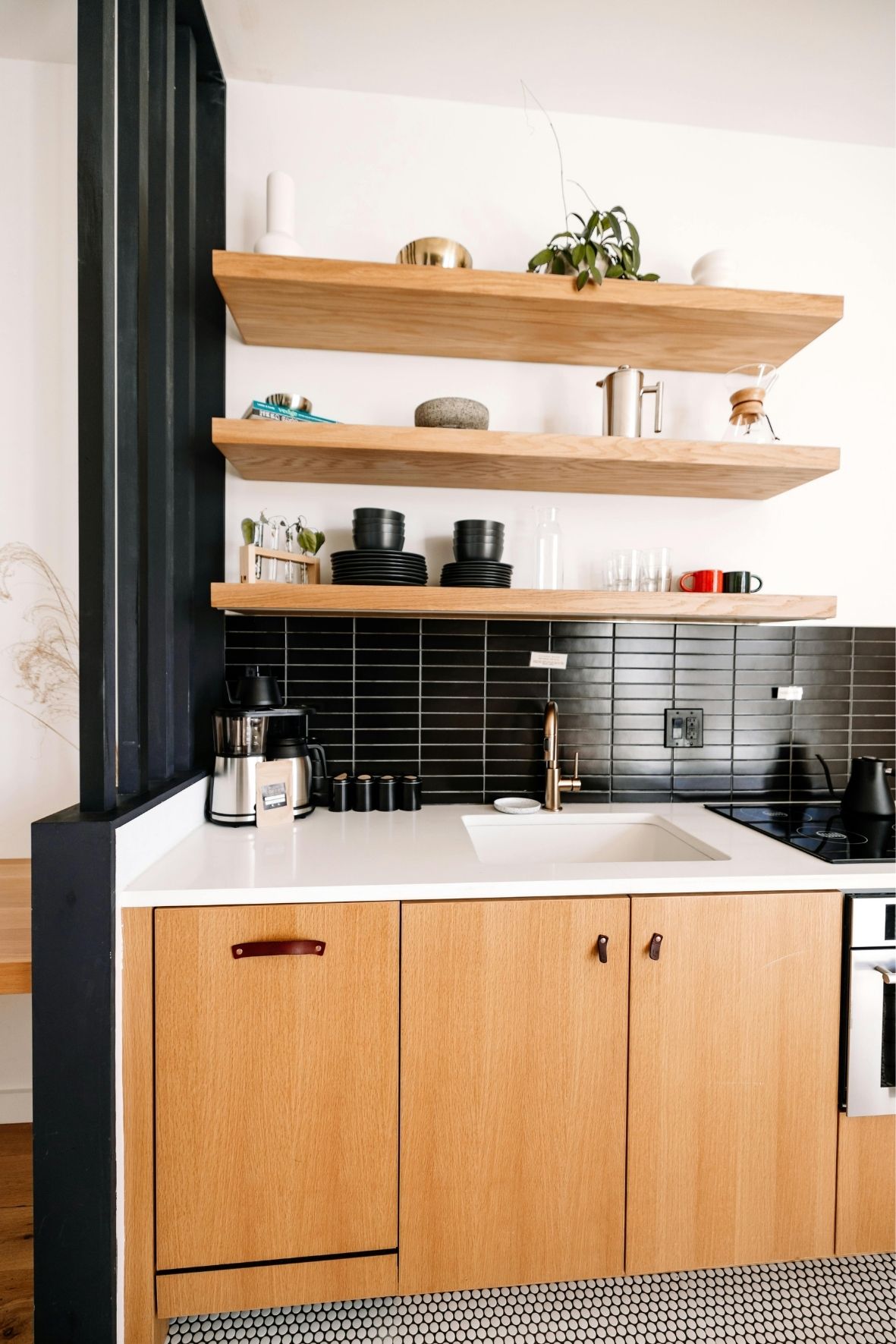 Cuisine fermée avec armoires foncées, crédence décorative et coin repas intégré dans un logement résidentiel au Québec